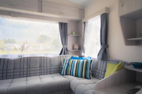 a living room with a white couch and a window at CHALETS IN THE DUNES nearby the beach in IJmuiden