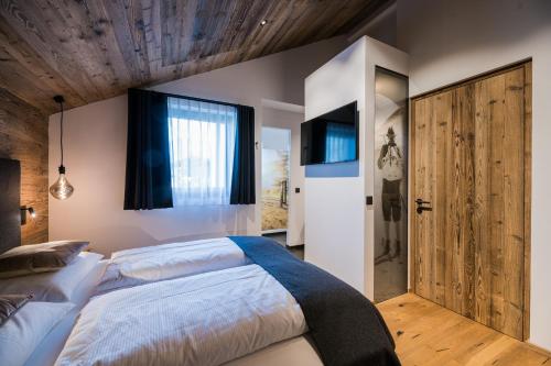ein Schlafzimmer mit einem großen Bett und einer Holzdecke in der Unterkunft Chalet Ortles M in Sankt Valentin auf der Haide