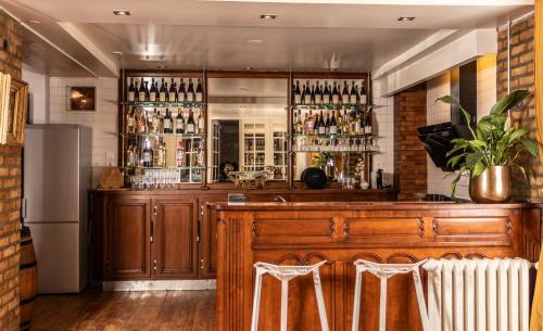 - un bar avec deux tabourets blancs dans une pièce dans l'établissement TheRoyals, à Reims