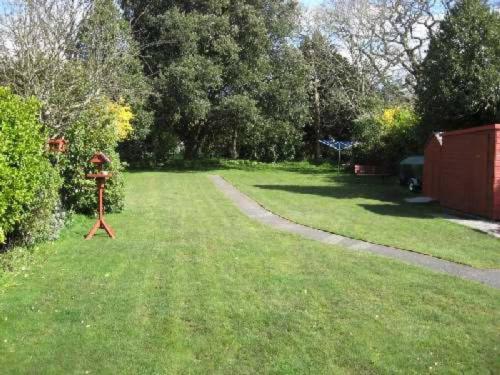 un patio con un alimentador de aves en la hierba en BOURNECOAST: LOVELY BUNGALOW NEAR THE SEA - HB2087, en Bournemouth