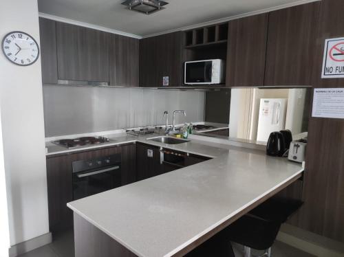 a kitchen with wooden cabinets and a counter top at Alojamiento en la Serena - Chile in La Serena