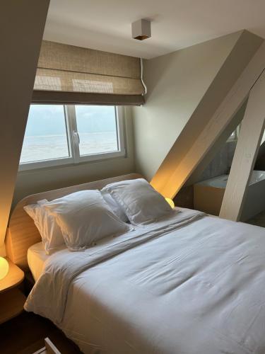 ein Schlafzimmer mit einem großen Bett mit einer Leiter in der Unterkunft Face à la mer in Gravelines