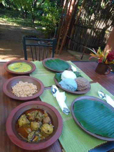 a wooden table with plates of food on it at Dambulla Tree House in Dambulla