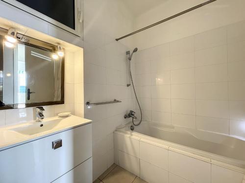 uma casa de banho branca com um lavatório e uma banheira em Appartement Cannes, 2 pièces, 4 personnes - FR-1-470-11 em Cannes