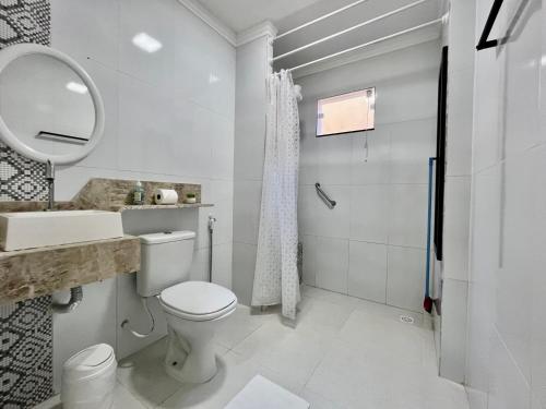 Baño blanco con aseo y lavamanos en Bella Peroba Flats #4 Tiffany - Maragogi - AL ' Acessibilidade Kids en Maragogi