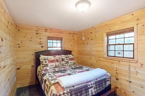 a bedroom with a bed in a log cabin at Weirs Boulevard Dreamin' in Laconia