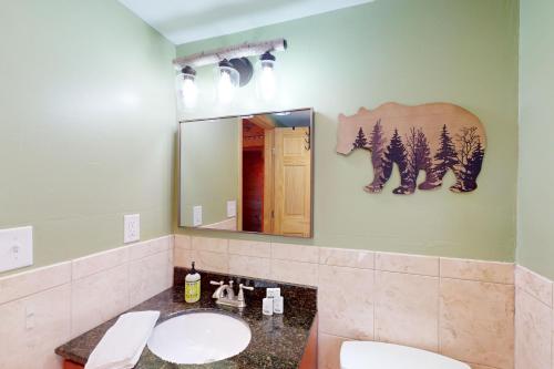 a bathroom with two sinks and a mirror at Weirs Boulevard Dreamin' in Laconia