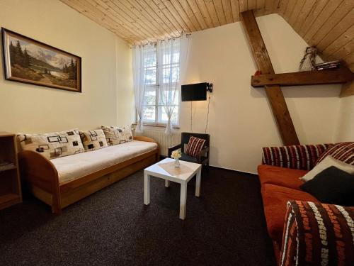 a living room with a couch and a table at Pension Fortuna in Halenkov