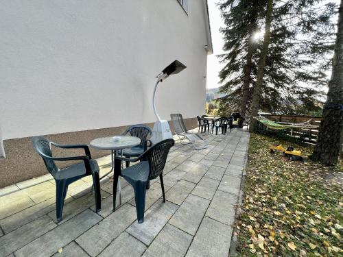 een tafel en stoelen en een lamp op een patio bij Pension Fortuna in Halenkov