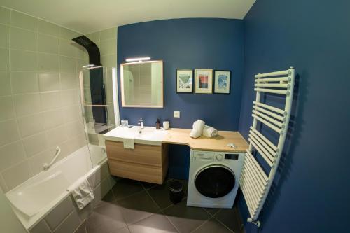 a bathroom with a sink and a washing machine at La Ruche des carrés - T3 vue panoramique in Annecy