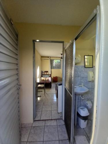 a hallway leading to a bathroom with a sink at Hotel em SBO - Centro in Santa Bárbara dʼOeste