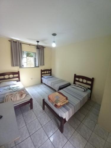 a room with two beds and a table in it at Hotel em SBO - Centro in Santa Bárbara dʼOeste