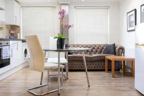 uma sala de estar com uma mesa e um sofá em London Boutique Apartments em Londres