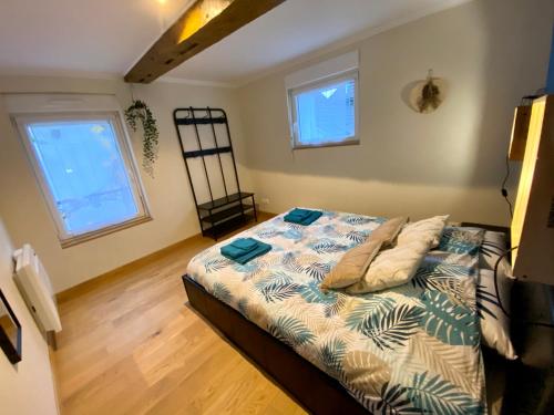 a bedroom with a bed and two windows at Les bulles agéennes in Ay