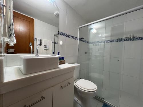 a bathroom with a sink and a toilet and a shower at Loft encantador em Praia do Forte próximo à Vila. in Praia do Forte