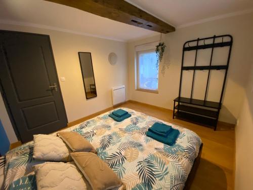 Un dormitorio con una cama con toallas azules. en Les bulles agéennes, en Ay