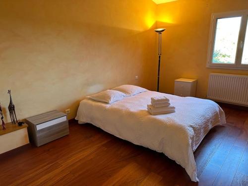 um quarto com uma cama com toalhas em La maison de pierres onches em Anduze
