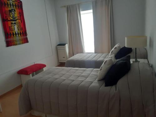 a bedroom with two beds and a window at Tu lugar en Rada Tilly in Rada Tilly