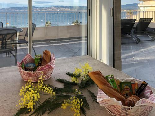 - une table avec deux paniers de pain et de fleurs dans l'établissement Appartement 2P avec Balcon, Clim, à 50m de la Plage et Centre-ville, WiFi et Parking Disponibles - FR-1-466A-3, à Saint-Raphaël