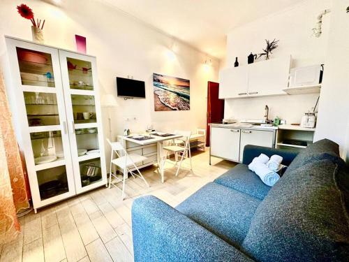 a living room with a blue couch and a kitchen at Suite Rapallo Centro - Mare & Wifi in Rapallo