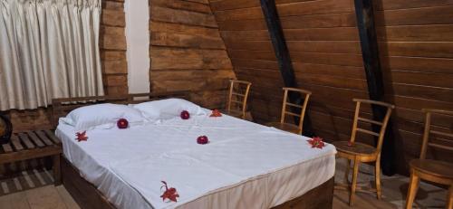 a bedroom with a bed with red apples on it at Ayu Bliss Elamulla, Mandaramnuwara in Mandaran Newara