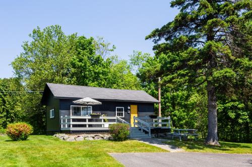a tiny house with a porch and a tree at Seascape Motel & Cottages in Belfast