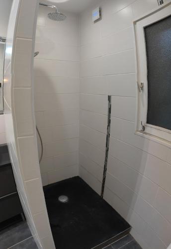 Lassigny的住宿－Grande Chambre Cosy avec Salle de Bain Privative，浴室铺有黑色地板,配有淋浴