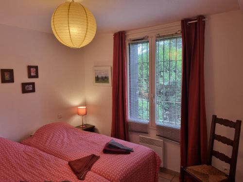 ein Schlafzimmer mit einem Bett und einem Fenster mit roten Vorhängen in der Unterkunft Villa El Còrrec in Laroque-des-Albères