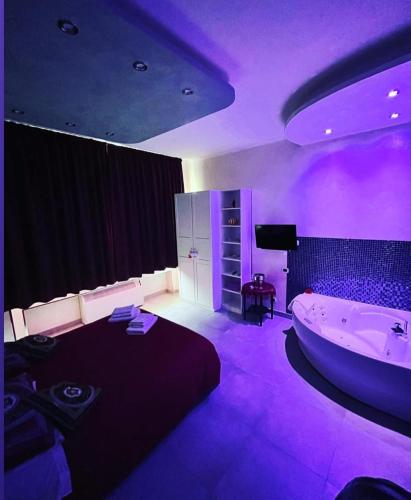 een paarse kamer met een bad en een bed bij Giulia's house Roma in Rome