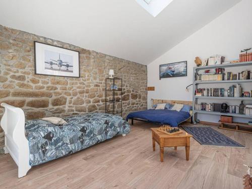 une chambre avec un lit et un mur en pierre dans l'établissement Villa 4P avec jardin, Wifi, à 500m des plages - Carnac - FR-1-477-159, à Carnac