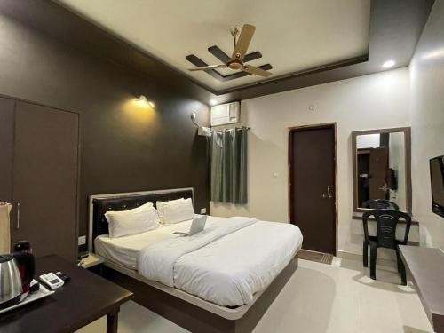 a bedroom with a bed with a ceiling fan at The White Canyon Hotel in Varanasi