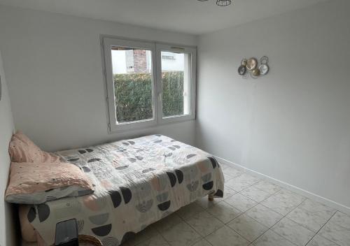 1 dormitorio con cama y ventana en Appartement avec petit jardin en Bagnères-de-Bigorre