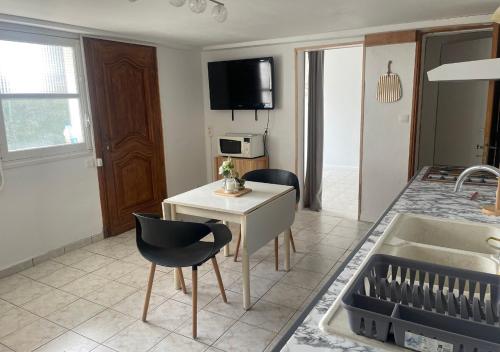cocina y sala de estar con mesa y sillas en Appartement avec petit jardin en Bagnères-de-Bigorre