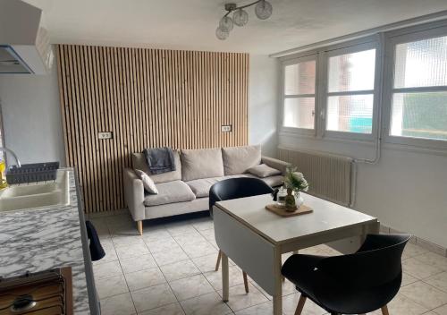 sala de estar con sofá y mesa en Appartement avec petit jardin en Bagnères-de-Bigorre