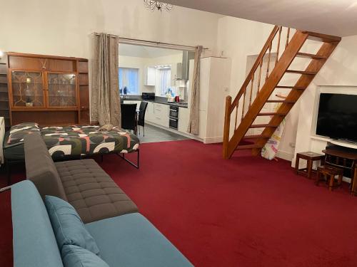 a living room with a couch and a television at Lovely Calm Independent Home in Belvedere