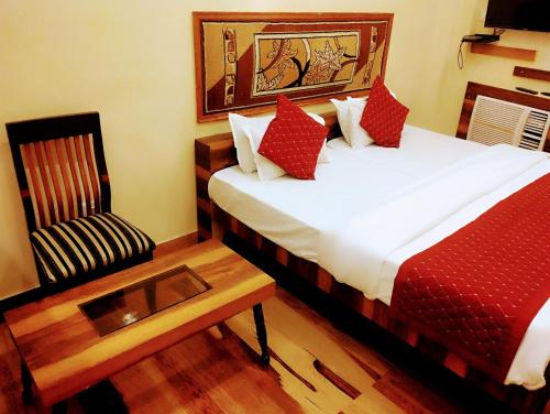 a hotel room with a bed and a chair at Bhagyashree Guest House in Varanasi