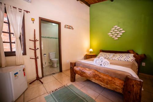 um quarto com uma cama e uma parede verde em Casa da Praia em Paraty