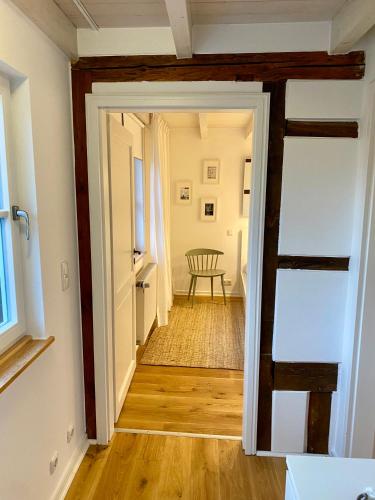 a hallway with a door open to a room with a chair at eichHAUS Eifel in Rheinbach