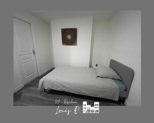 Habitación blanca con cama y puerta en Studio pour 2 Personnes --3, en Béthune