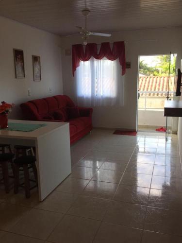 uma sala de estar com um sofá vermelho e uma mesa em Apartamento em Penha-SC em Penha