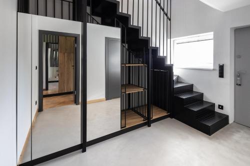 a staircase in a house with black railings at Lemon Resort Spa in Gródek Nad Dunajcem