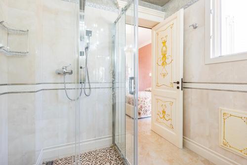 uma casa de banho com um chuveiro e uma porta de vidro em Villa Vanessa em Castrignano del Capo