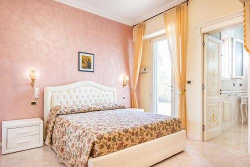 um quarto com uma cama branca e uma janela em Villa Vanessa em Castrignano del Capo