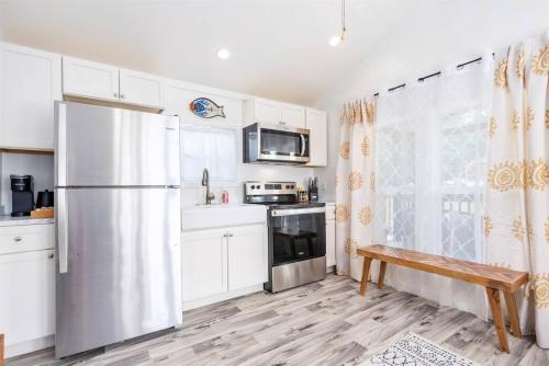 a kitchen with white cabinets and a stainless steel refrigerator at 5 Cozy Casita Lux Tiny House, Firepit, 5 Mins To Downtown Guntersville in Guntersville