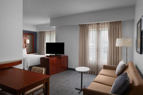 a hotel room with a couch and a bed at Residence Inn East Rutherford Meadowlands in East Rutherford
