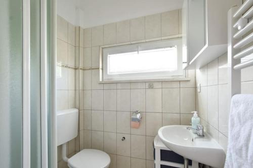 ein Bad mit einem Waschbecken, einem WC und einem Fenster in der Unterkunft Villa Batarelo in Sinj