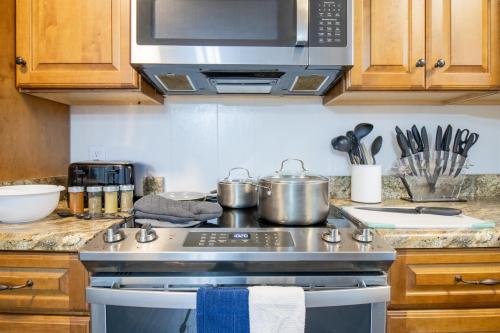 a kitchen with a stove with pots and pans at Home Away in Taylors by Brick and Home in Taylors
