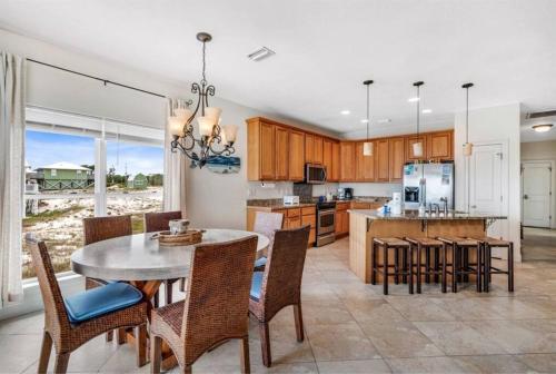 a kitchen and dining room with a table and chairs at Pet Friendly Ft Morgan Beach Home w/ Views! in Gulf Shores