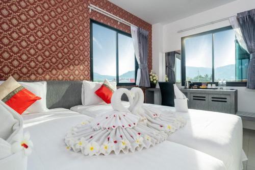 a bedroom with a white bed with a towel on it at The Thames Pool Access Resort & Villa - SHA Extra Plus in Chalong 
