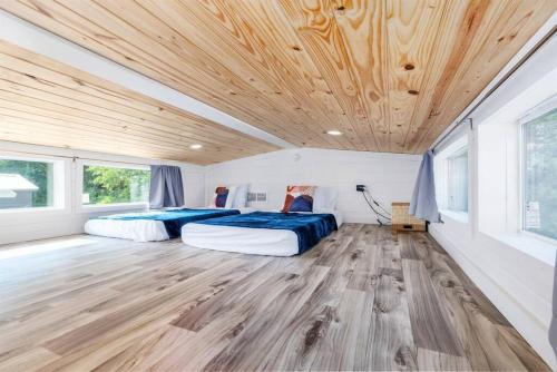 2 łóżka w pokoju z drewnianym sufitem w obiekcie 2 Villa D'Azur Luxury Tiny House Mins to Lake Guntersville, Downtown, Firepit w mieście Guntersville